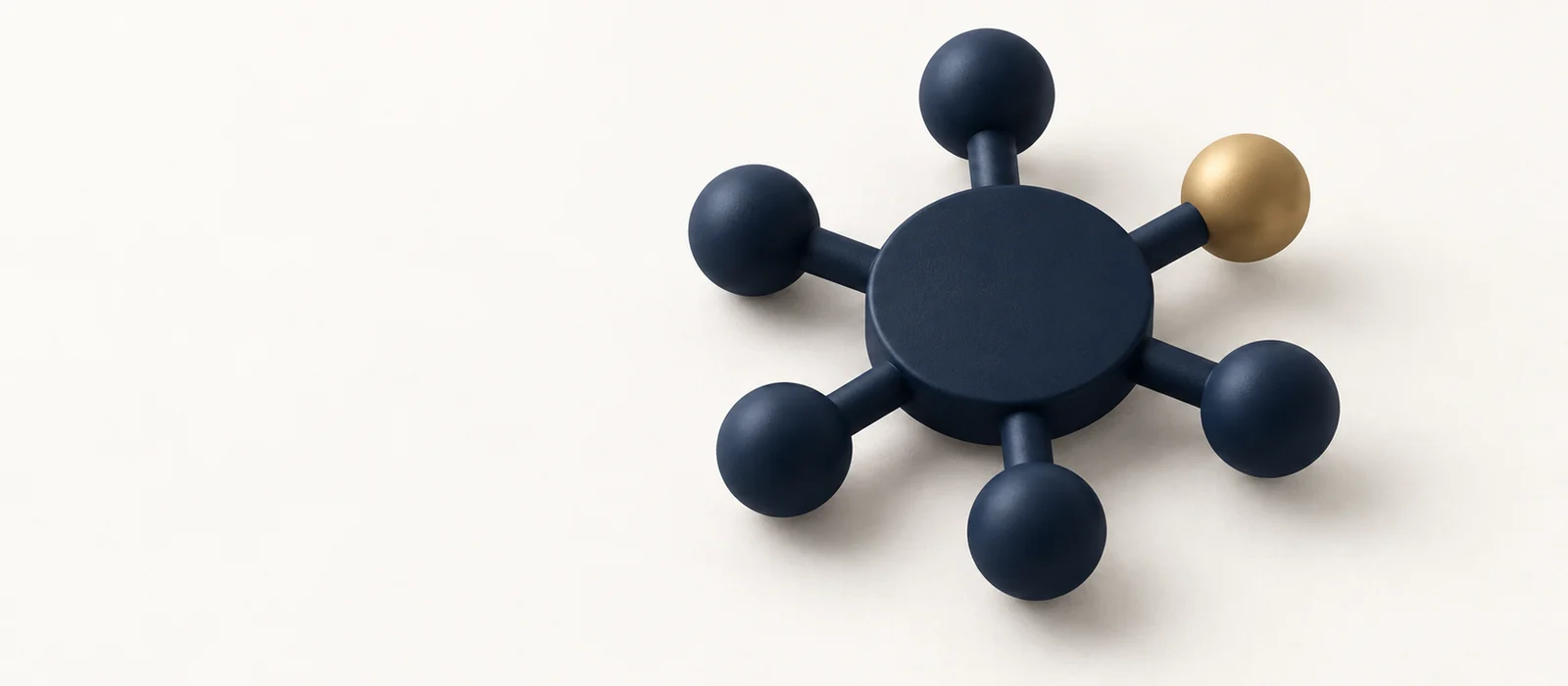 A matte navy hub with six spokes ending in spheres, one gold, on warm paper.